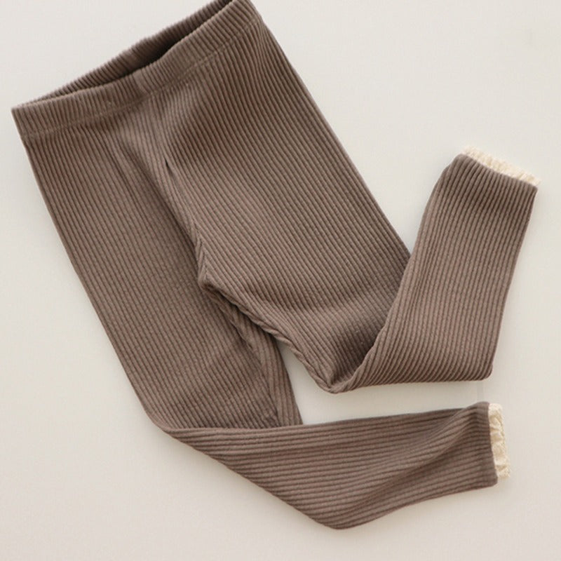 Babys und Mädchen tragen Leggings über Herbsthosen
