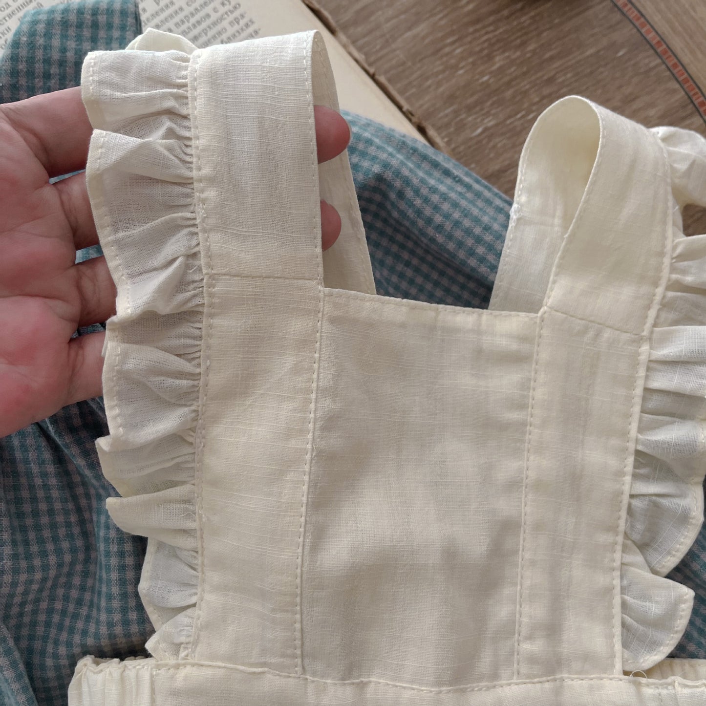 Baby-Strampler mit einreihiger Knopfleiste, langen Ärmeln, kleinem Karomuster, kleinem Überrock und Tragetuch