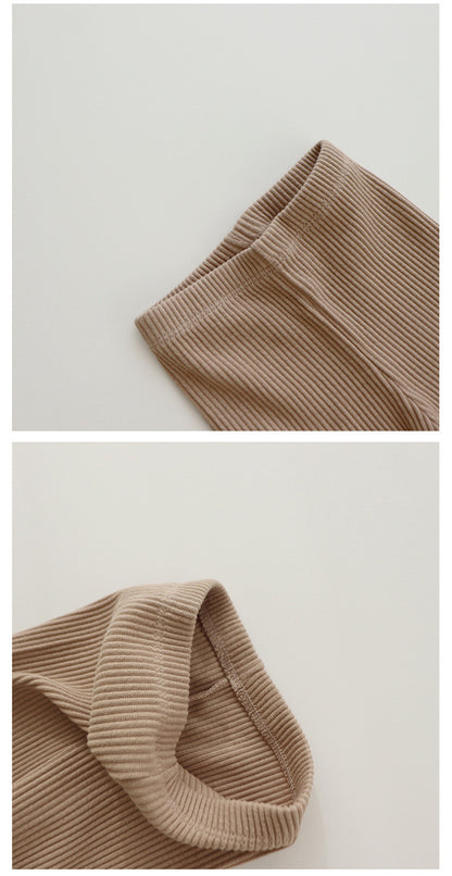 Babys und Mädchen tragen Leggings über Herbsthosen