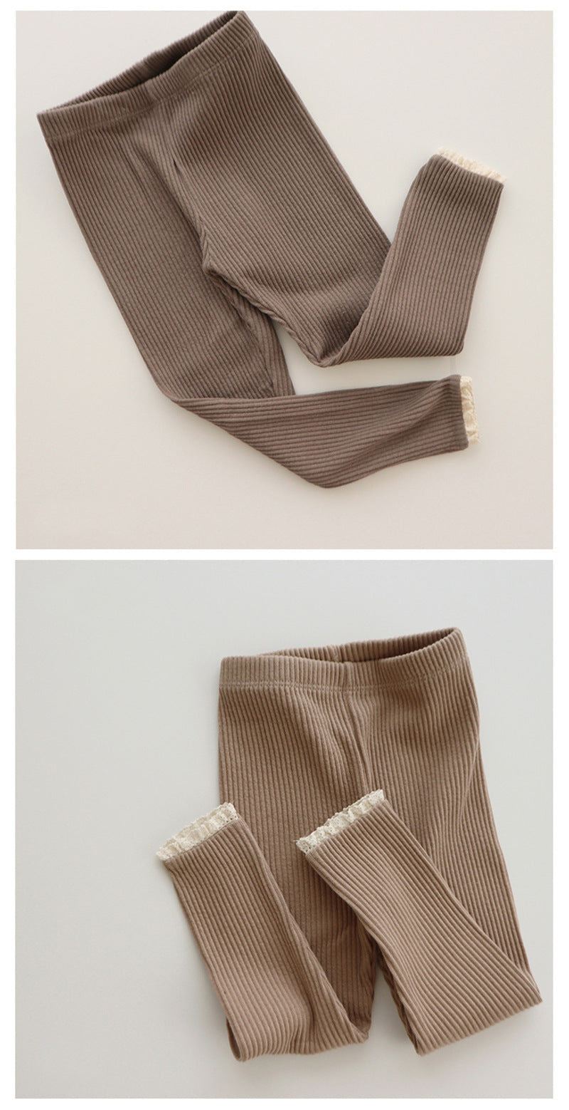 Babys und Mädchen tragen Leggings über Herbsthosen