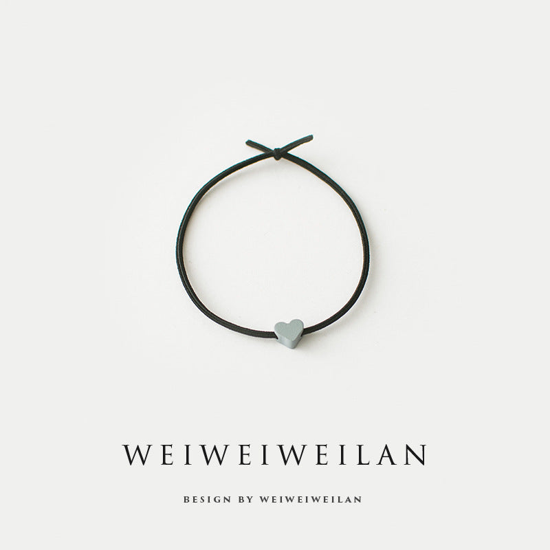 Einfaches, vielseitig kombinierbares Haargummi mit farbigem Herzmotiv