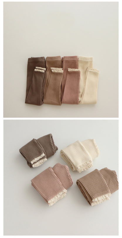 Babys und Mädchen tragen Leggings über Herbsthosen