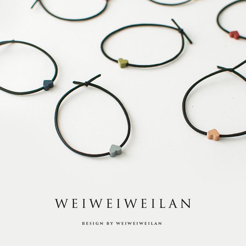 Einfaches, vielseitig kombinierbares Haargummi mit farbigem Herzmotiv