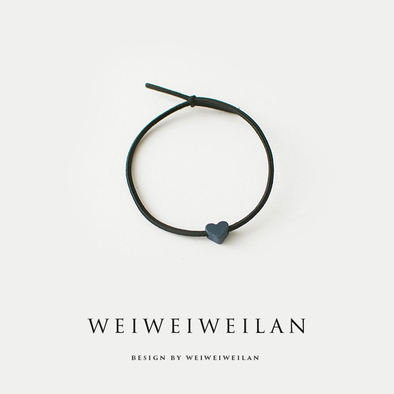 Einfaches, vielseitig kombinierbares Haargummi mit farbigem Herzmotiv