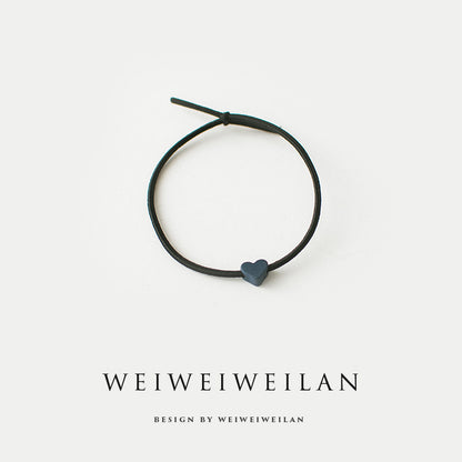 Einfaches, vielseitig kombinierbares Haargummi mit farbigem Herzmotiv