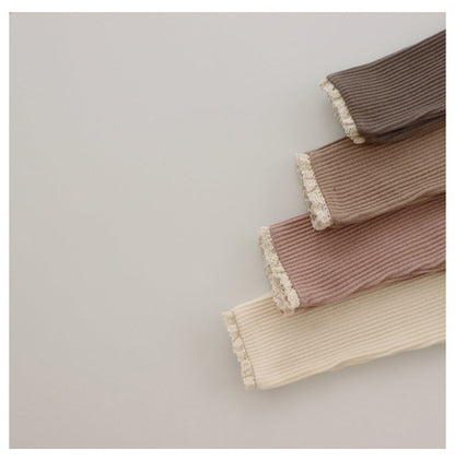 Babys und Mädchen tragen Leggings über Herbsthosen