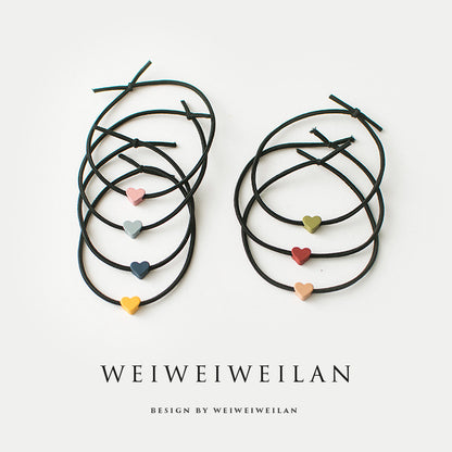 Einfaches, vielseitig kombinierbares Haargummi mit farbigem Herzmotiv