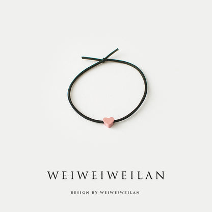 Einfaches, vielseitig kombinierbares Haargummi mit farbigem Herzmotiv